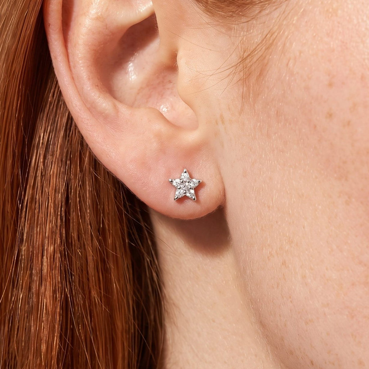 Woman wearing the Camila Star Stud Earrings on the lobe, featuring a tiny silver star with clear stones