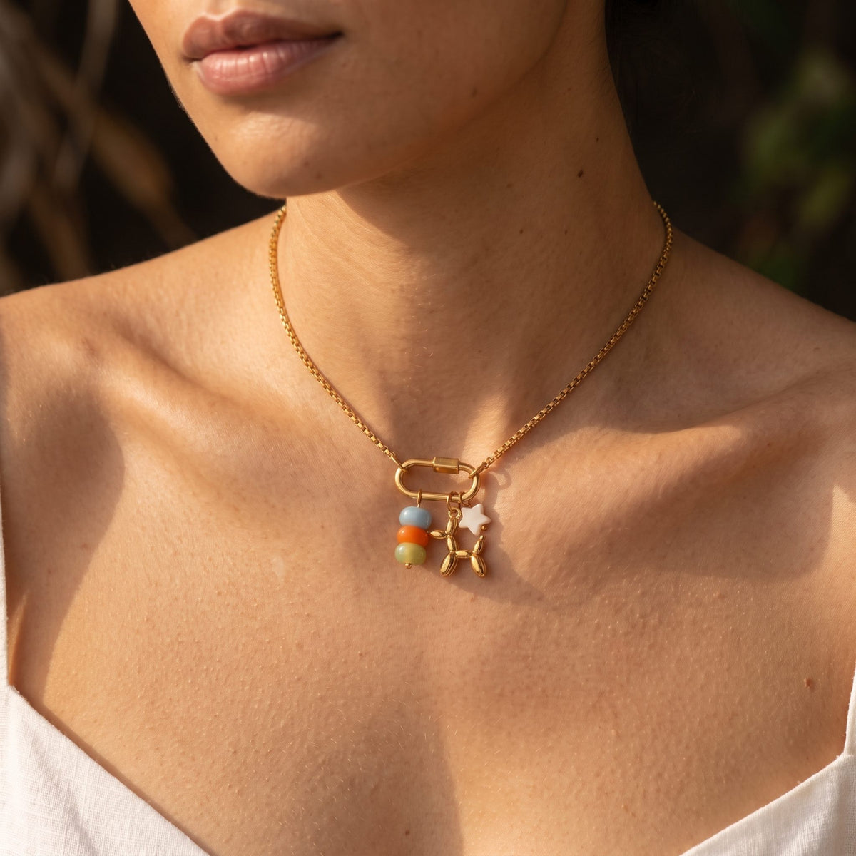 Woman wearing the Carabiner Charm Necklace on the neckline