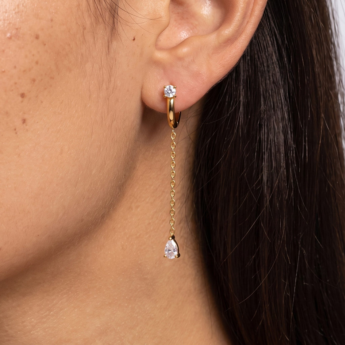 Close-up of the Chain Drop Earrings on the ear, showing a sparkling teardrop crystal