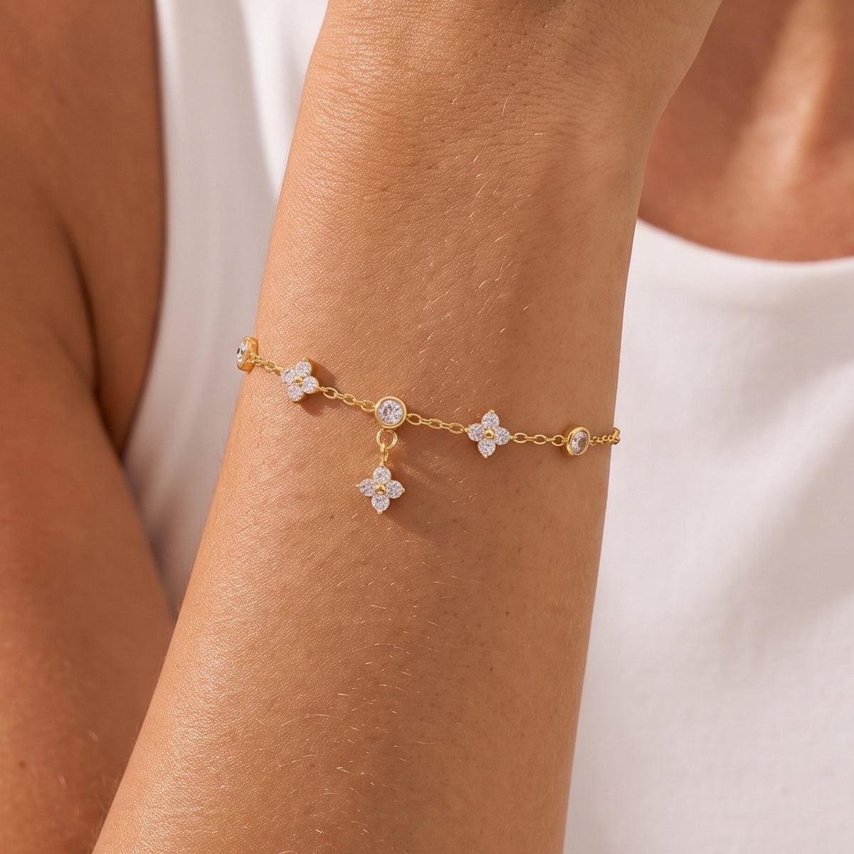 Close-up of the Clover Dangle Bracelet on her wrist highlighting its crystal floral charms