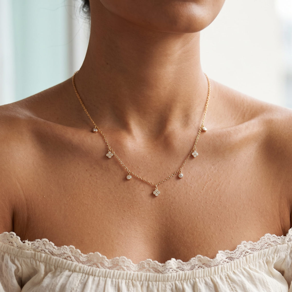 Wider view of a woman wearing the Clover Drop Necklace