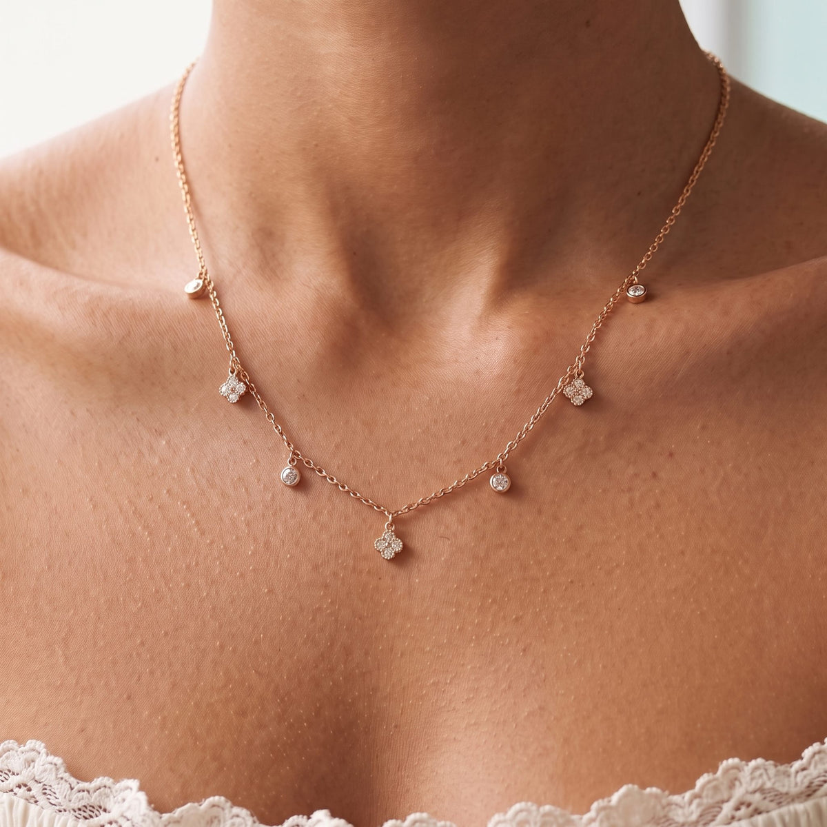 Close-up of the Clover Drop Necklace worn on the neckline, in rose gold