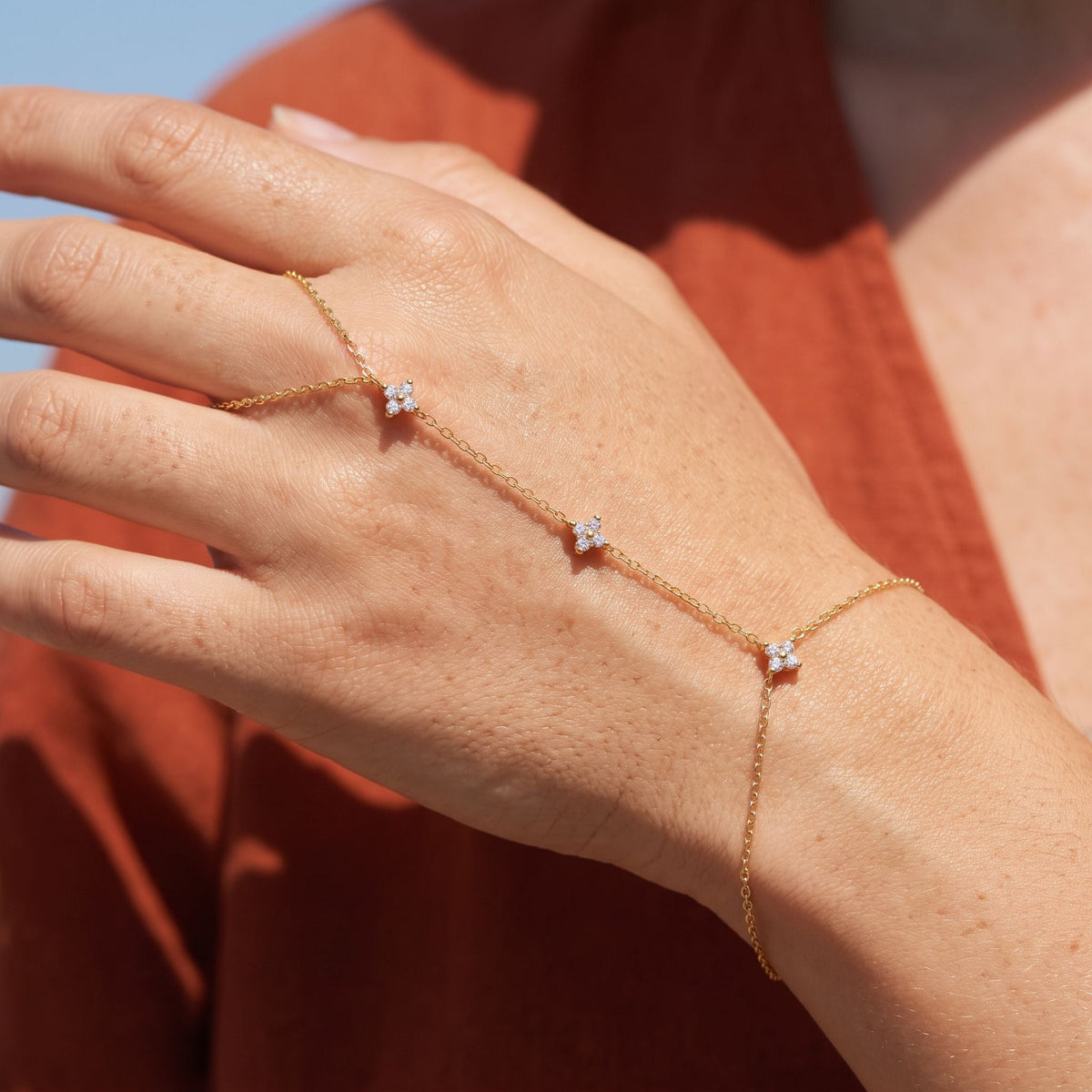 Clover Hand Chain worn across the back of the hand, with the ring on the finger and the chain at the wrist.
