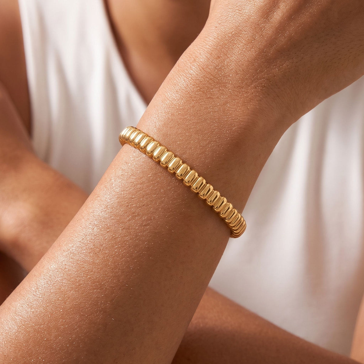 Coil Bangle worn on the wrist, photographed in natural daylight.