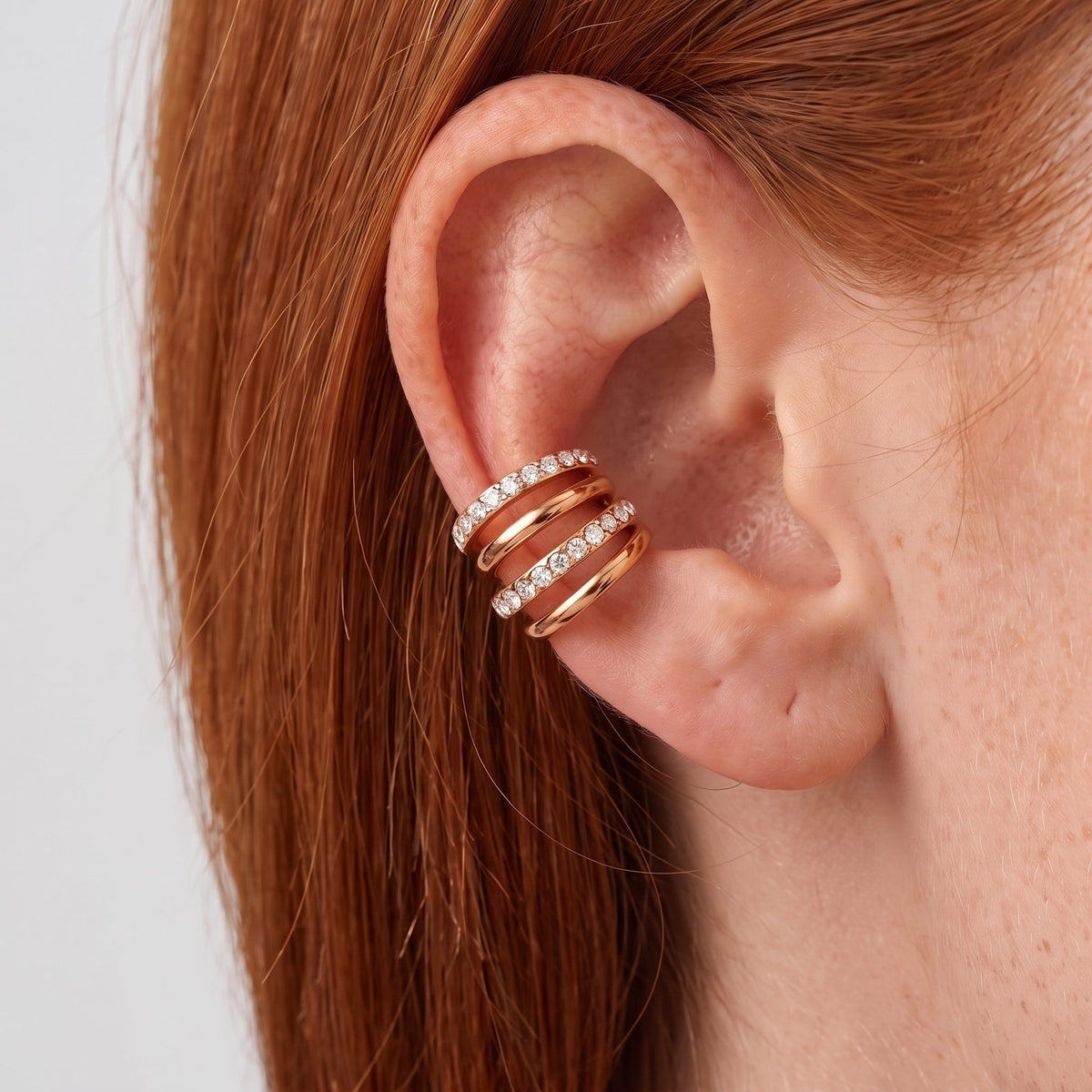 Close-up of the Crisscross Ear Cuffs on the ear, showing sparkling crystal bands, in rose gold