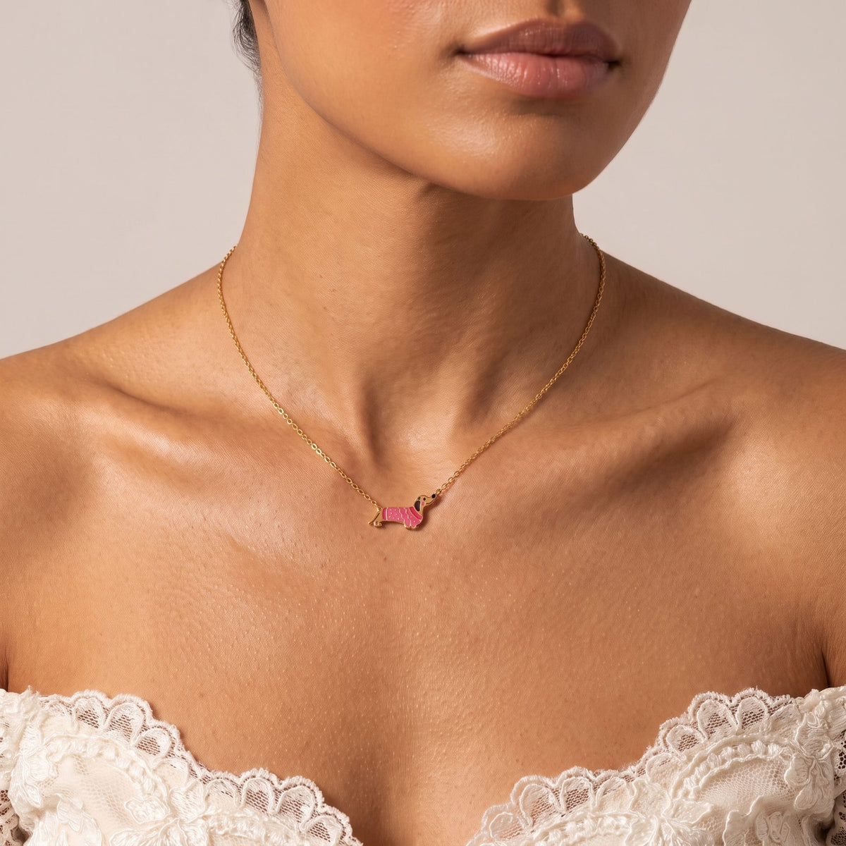 Woman wearing the Dachshund Pendant at the collarbone, styled with a lace off-the-shoulder top