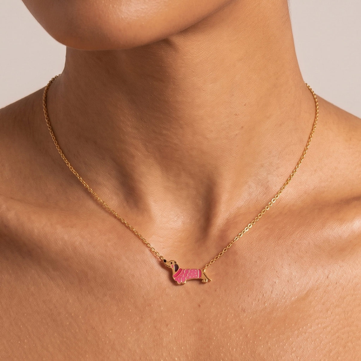 Close-up of the Dachshund Pendant worn at the collarbone, highlighting its pink patterned coat