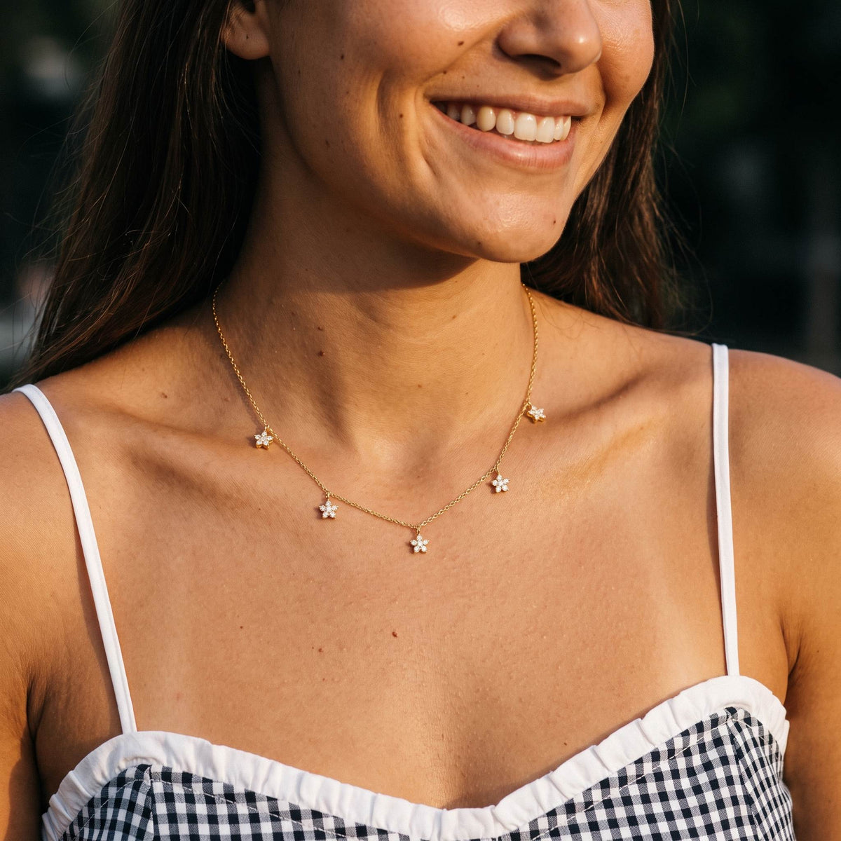 Wider view of a woman wearing the Daisy Charm Necklace