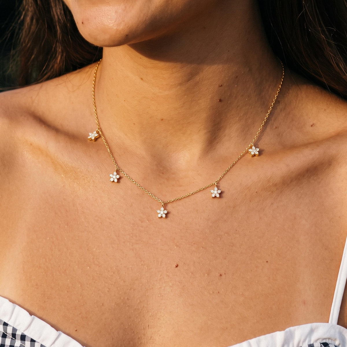 Close-up of the Daisy Charm Necklace worn on the neckline