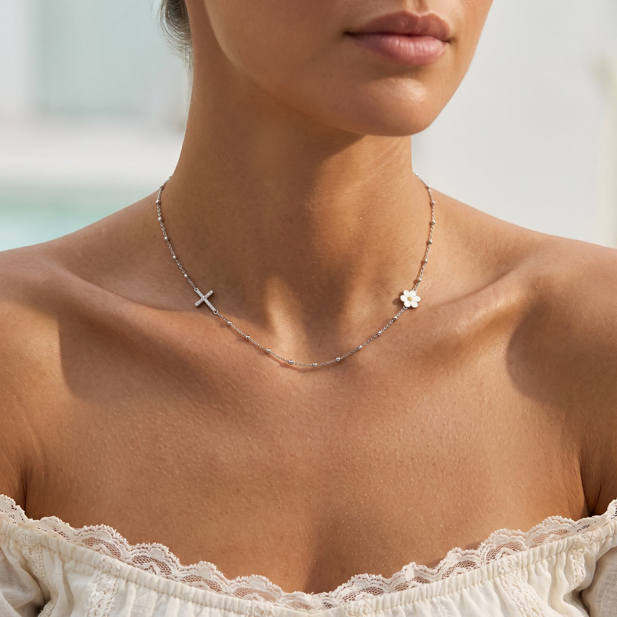 Wider view of a woman wearing the Daisy & Cross Necklace
