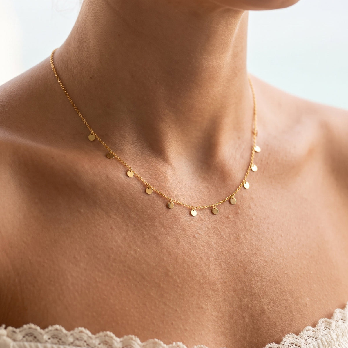 Close-up of the Disc Charm Necklace worn on the neckline