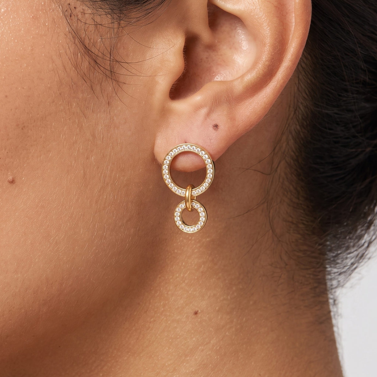 Close-up of the Double Circle Earrings on an ear, showing pave-set sparkling crystals