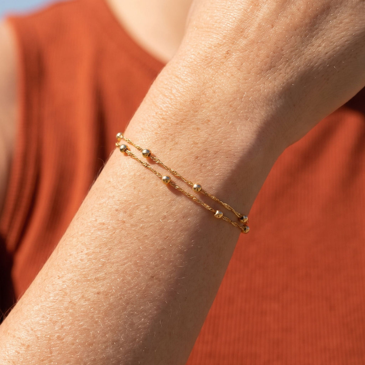 Double Satellite Bracelet worn on the wrist, photographed in natural daylight.