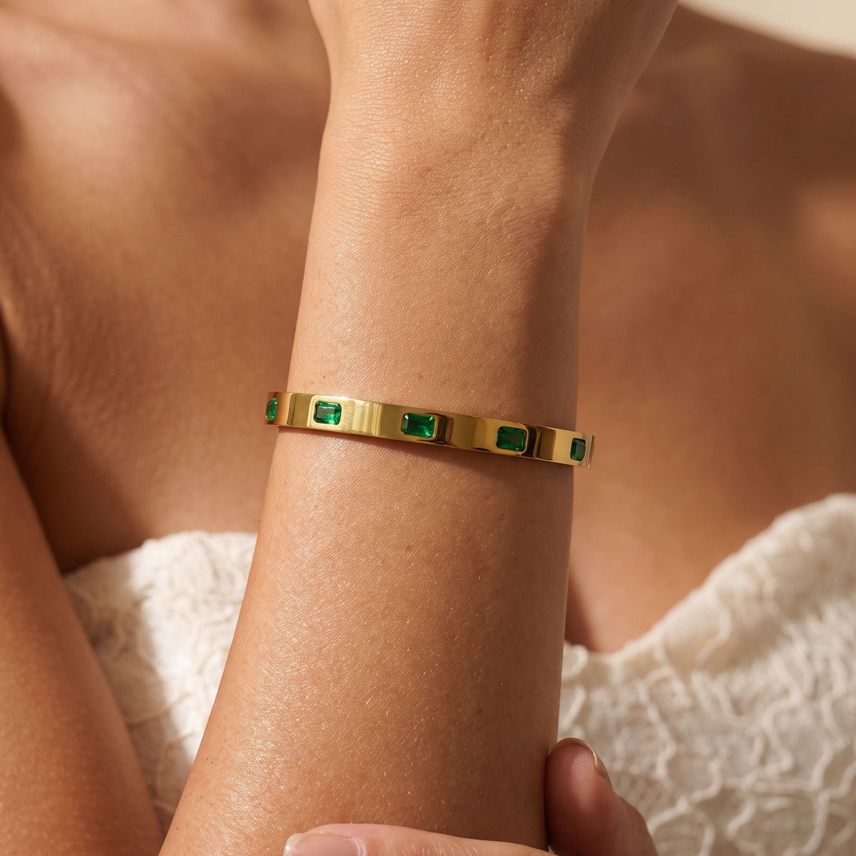 Emerald Baguette Bangle worn on the wrist, photographed in natural daylight.