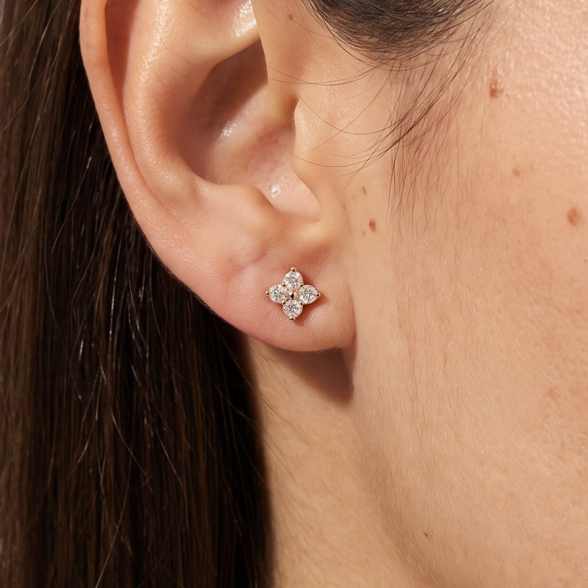 Woman wearing the Emma Crystal Clover Studs on the lobe, showing the gold four-petal crystal design