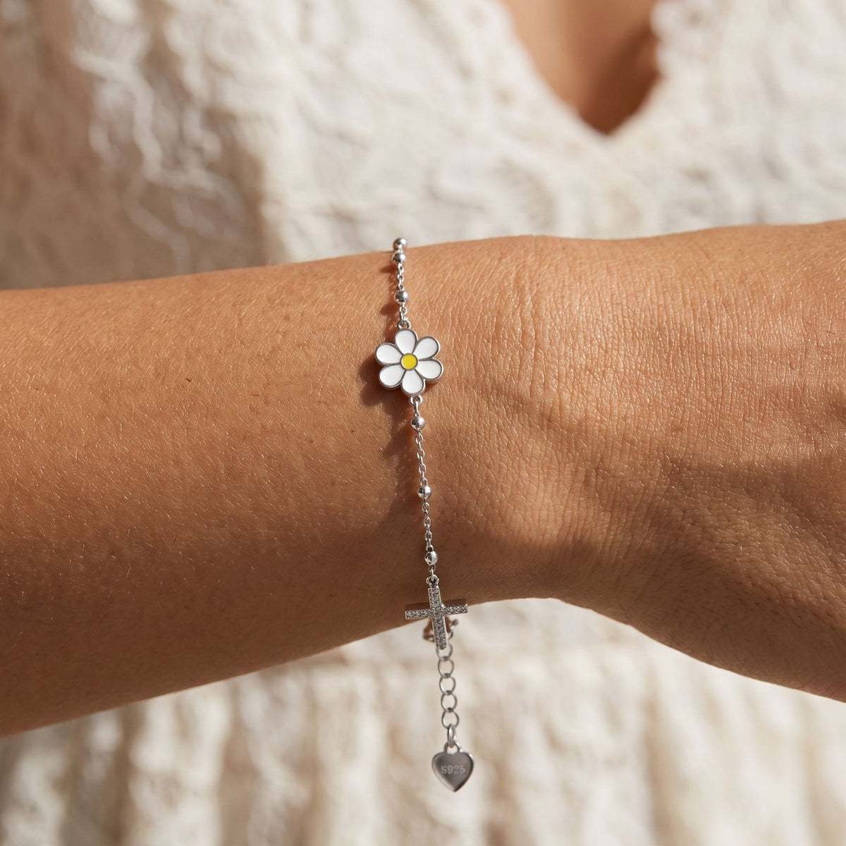 Enamel Daisy Bracelet worn on the wrist, photographed in natural daylight.