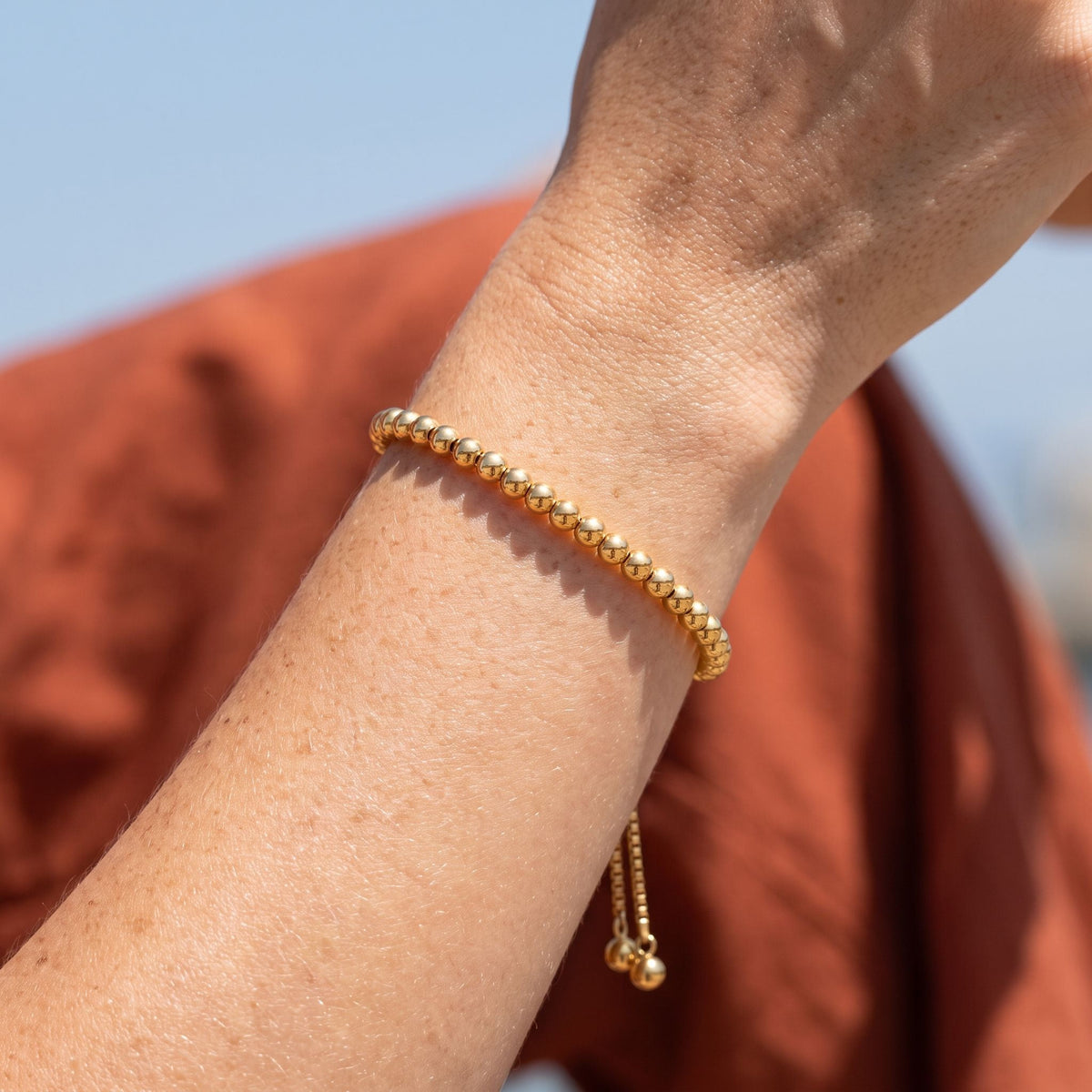 Gold Bead Bracelet worn on the wrist, photographed in natural daylight.