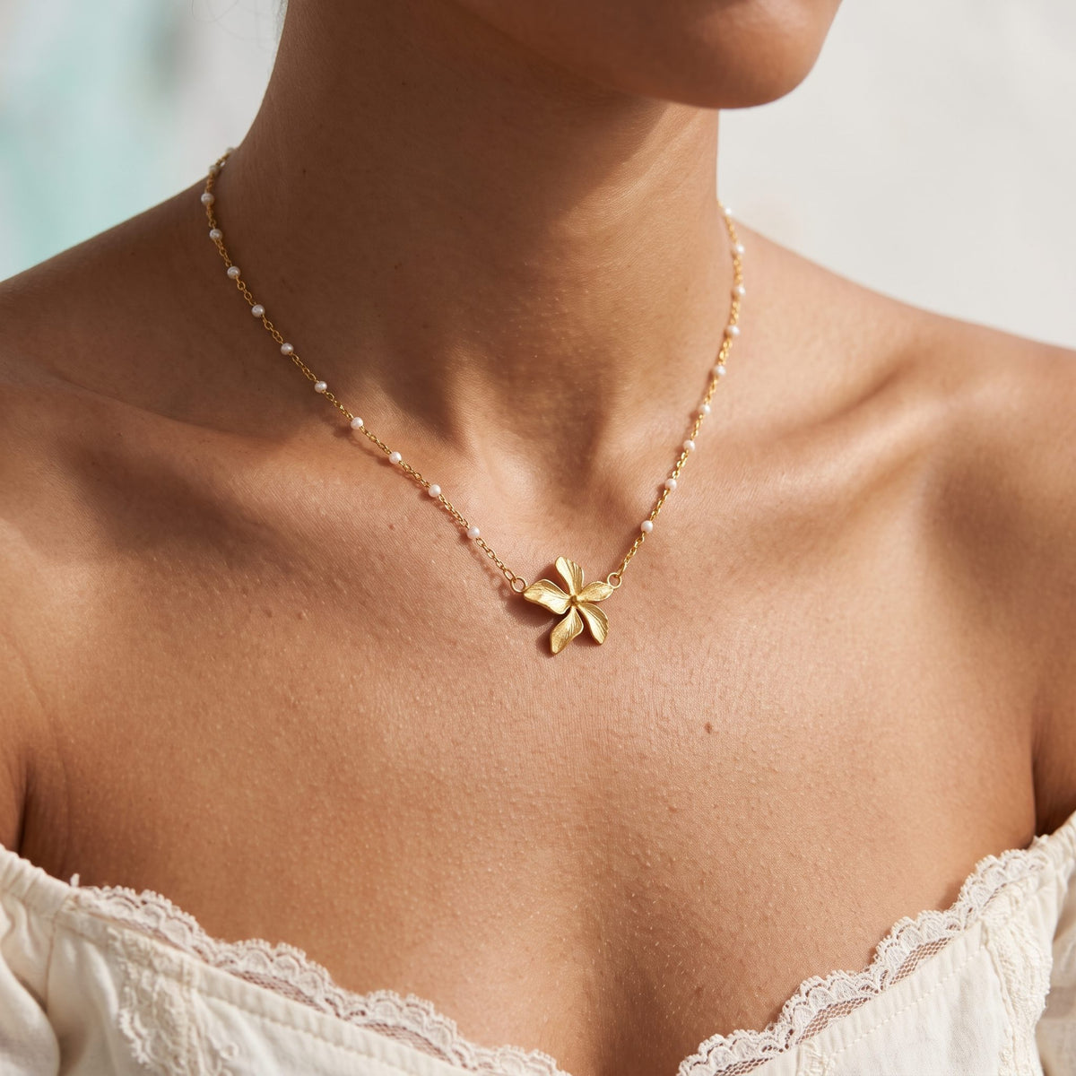 Wider view of a woman wearing the Gold Bloom Necklace