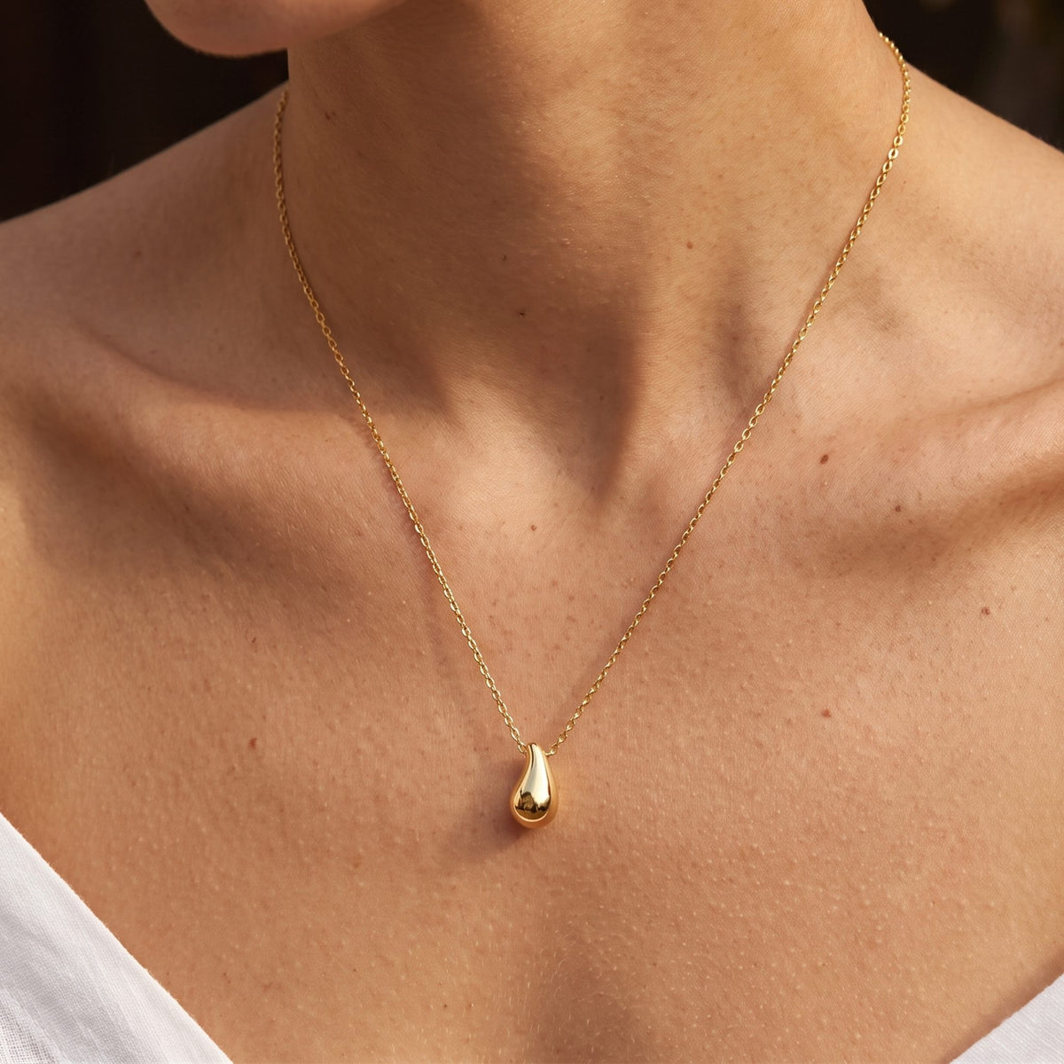 Close-up of the Gold Drop Pendant worn on the neckline