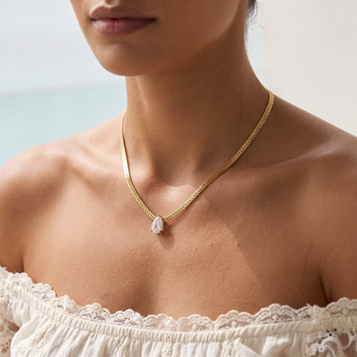 Wider view of a woman wearing the Gold Pear Necklace
