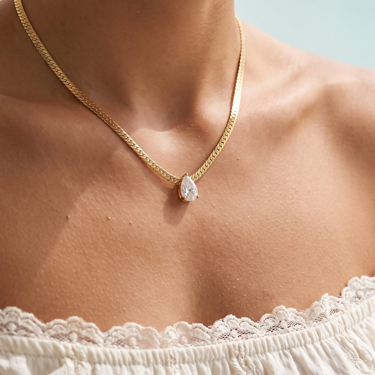 Close-up of the Gold Pear Necklace worn on the neckline