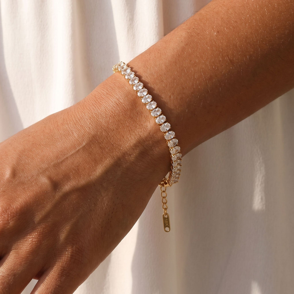 Gold Tennis Bracelet worn on the wrist, photographed in natural daylight.