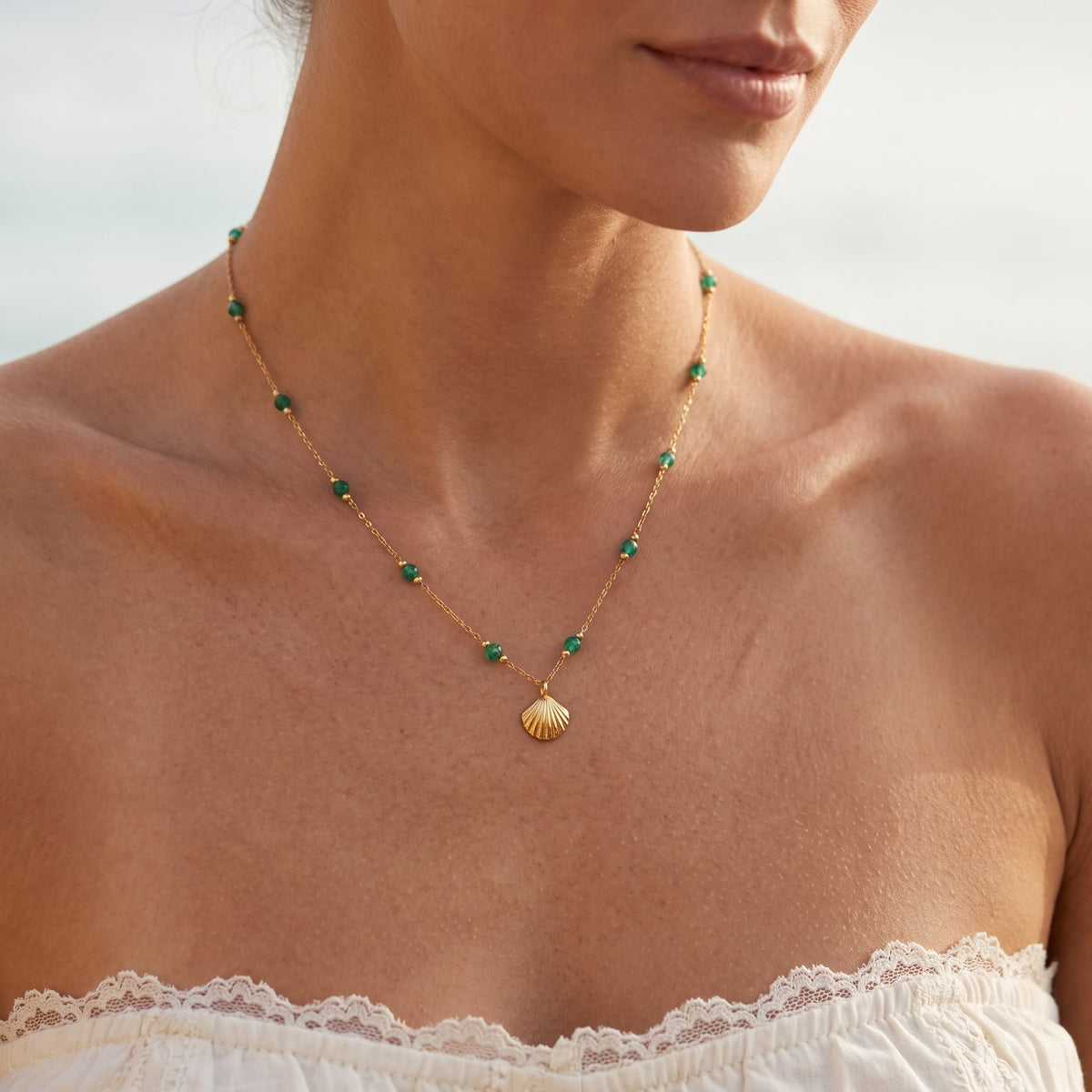 Wider view of a woman wearing the Green Shell Necklace