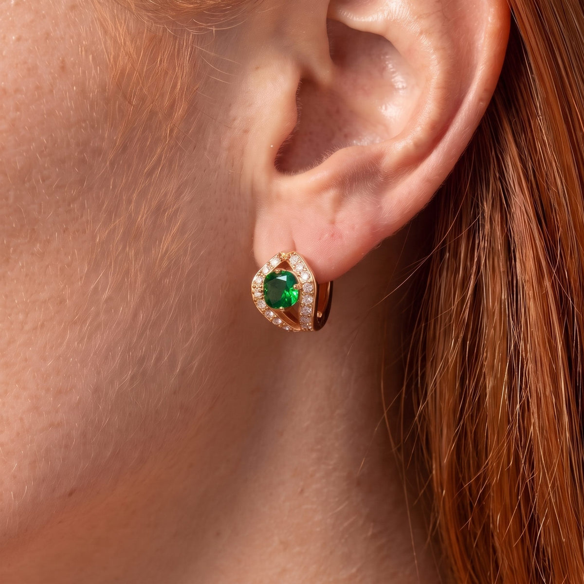 Close-up of the Green Split Halo Huggies on an ear, showing the bright green crystal and rose gold split halo
