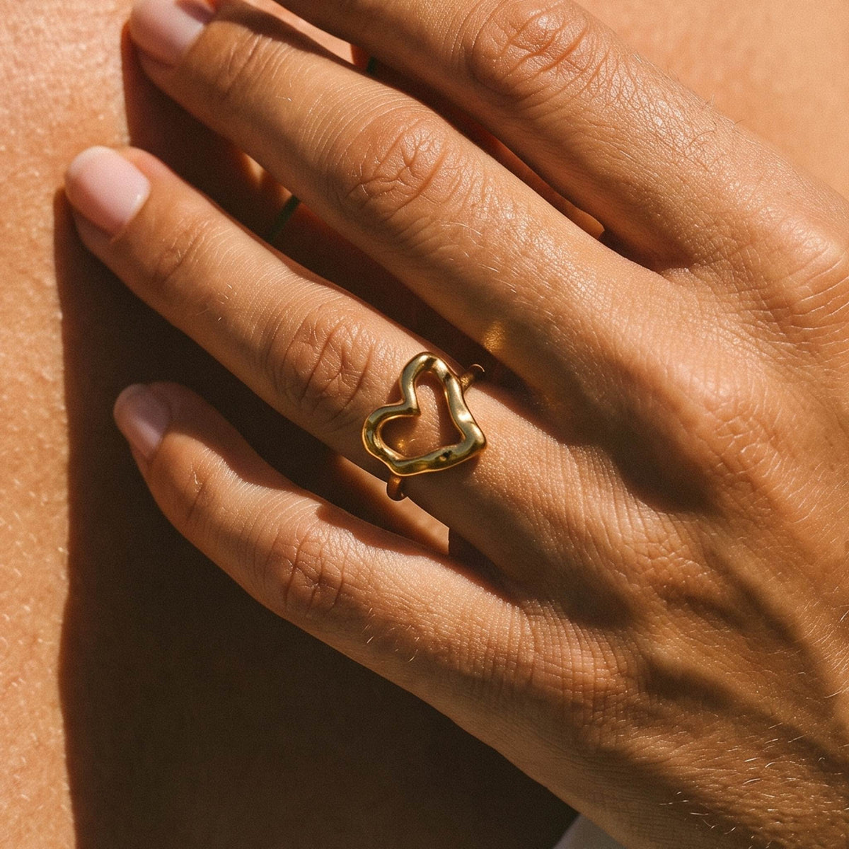 Close-up of the Hammered Heart Ring worn on the finger