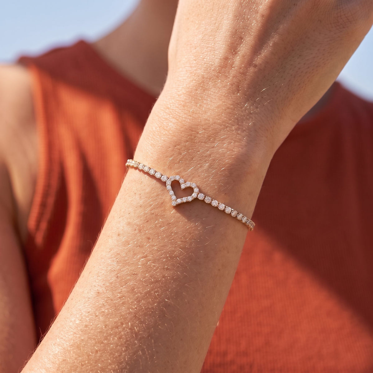 Heart Tennis Bracelet in rose gold worn on the wrist, photographed in natural daylight