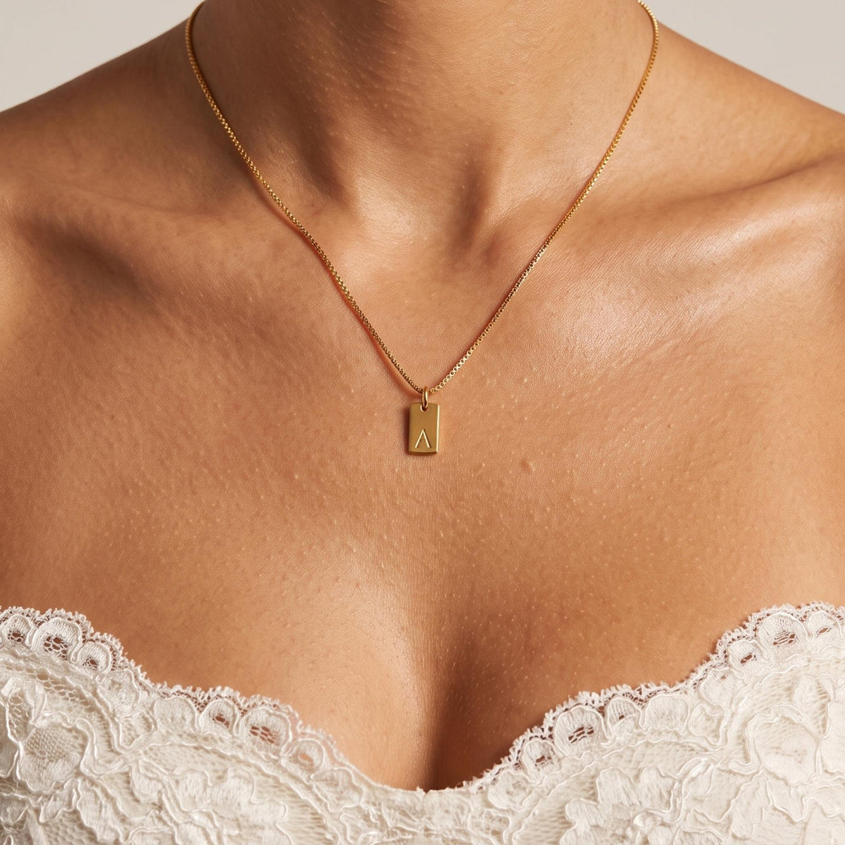 Close-up of the Initial Tag Necklace worn on the neckline