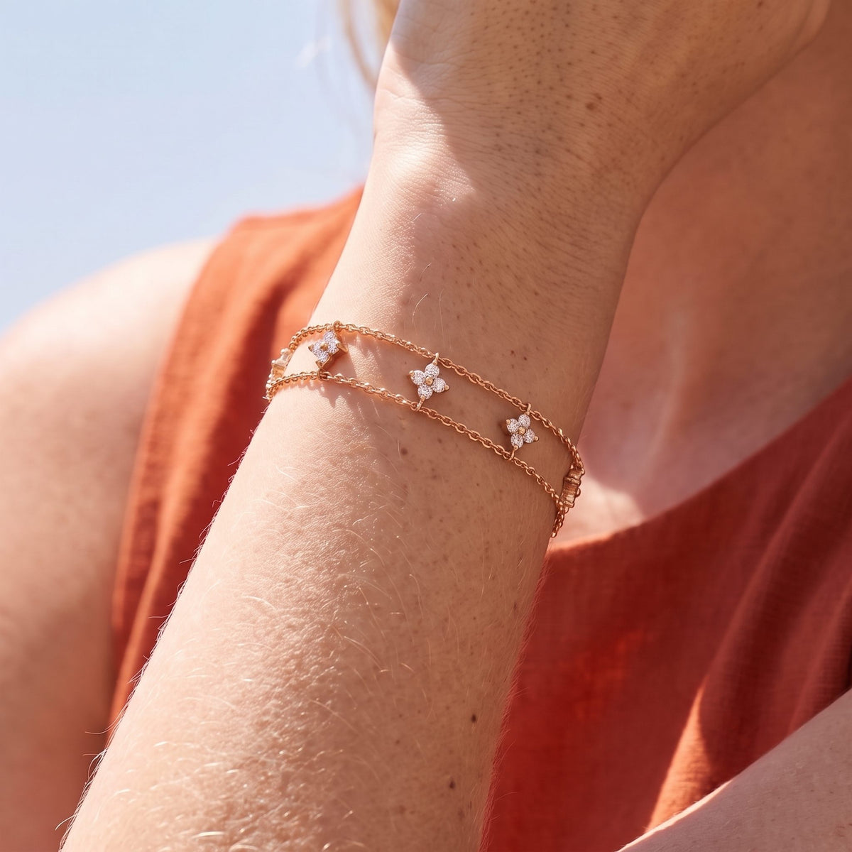 Close-up of the Layered Clover Bracelet on the wrist, highlighting its sparkling crystal clover charms, in rose gold