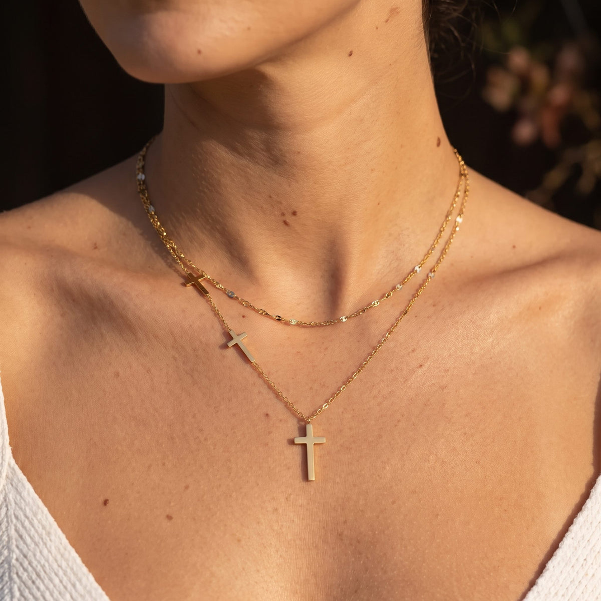 Woman wearing the Layered Cross Necklace on the neckline