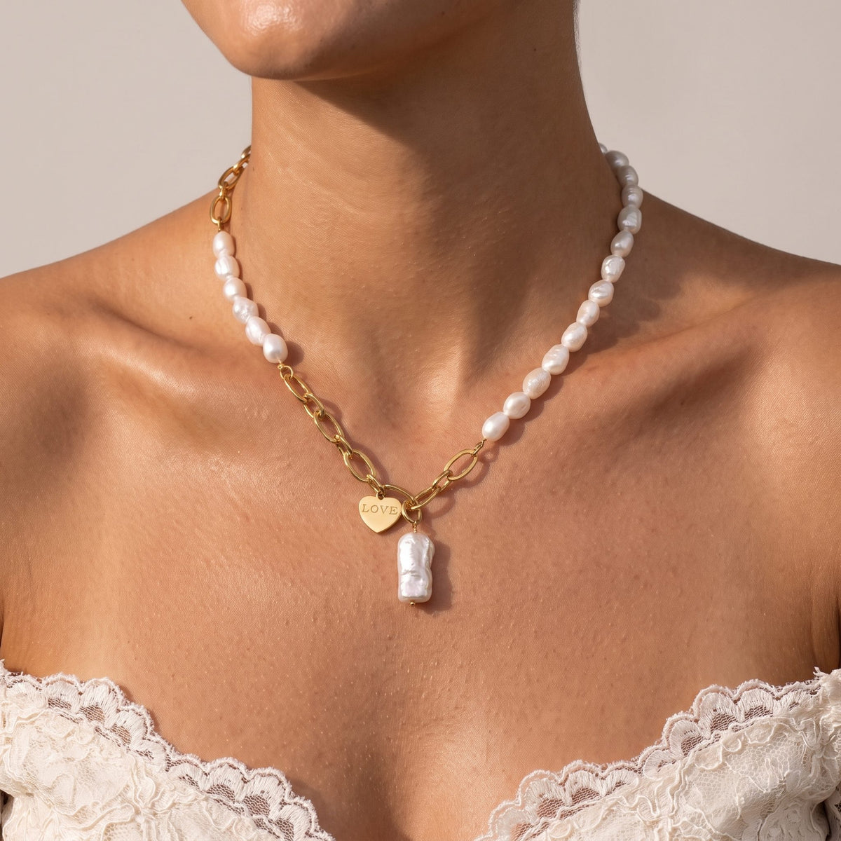 Woman wearing the Love Tag Necklace at the collarbone, paired with a lace top