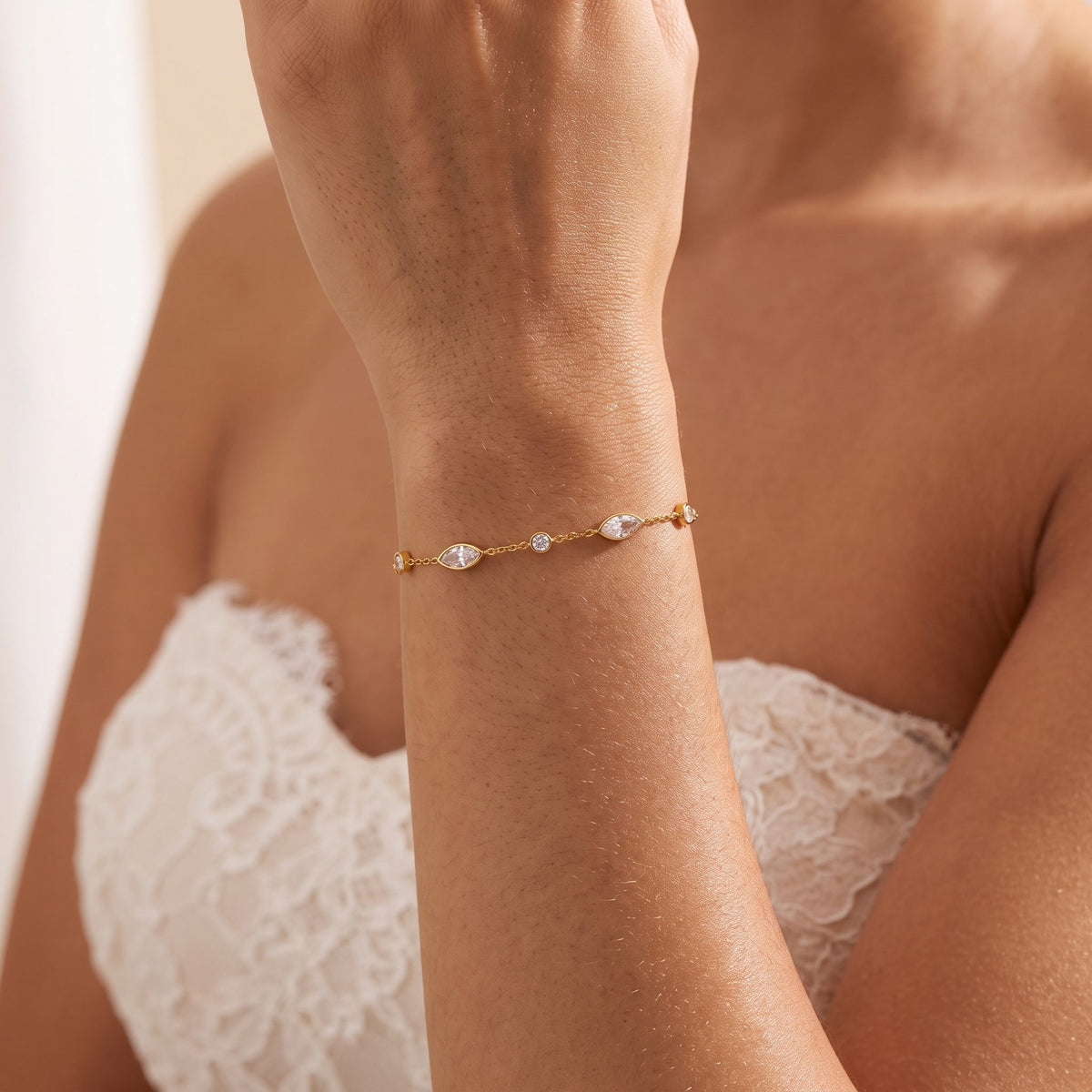 Woman wearing the Marquise Station Bracelet on her wrist, paired with a lace dress