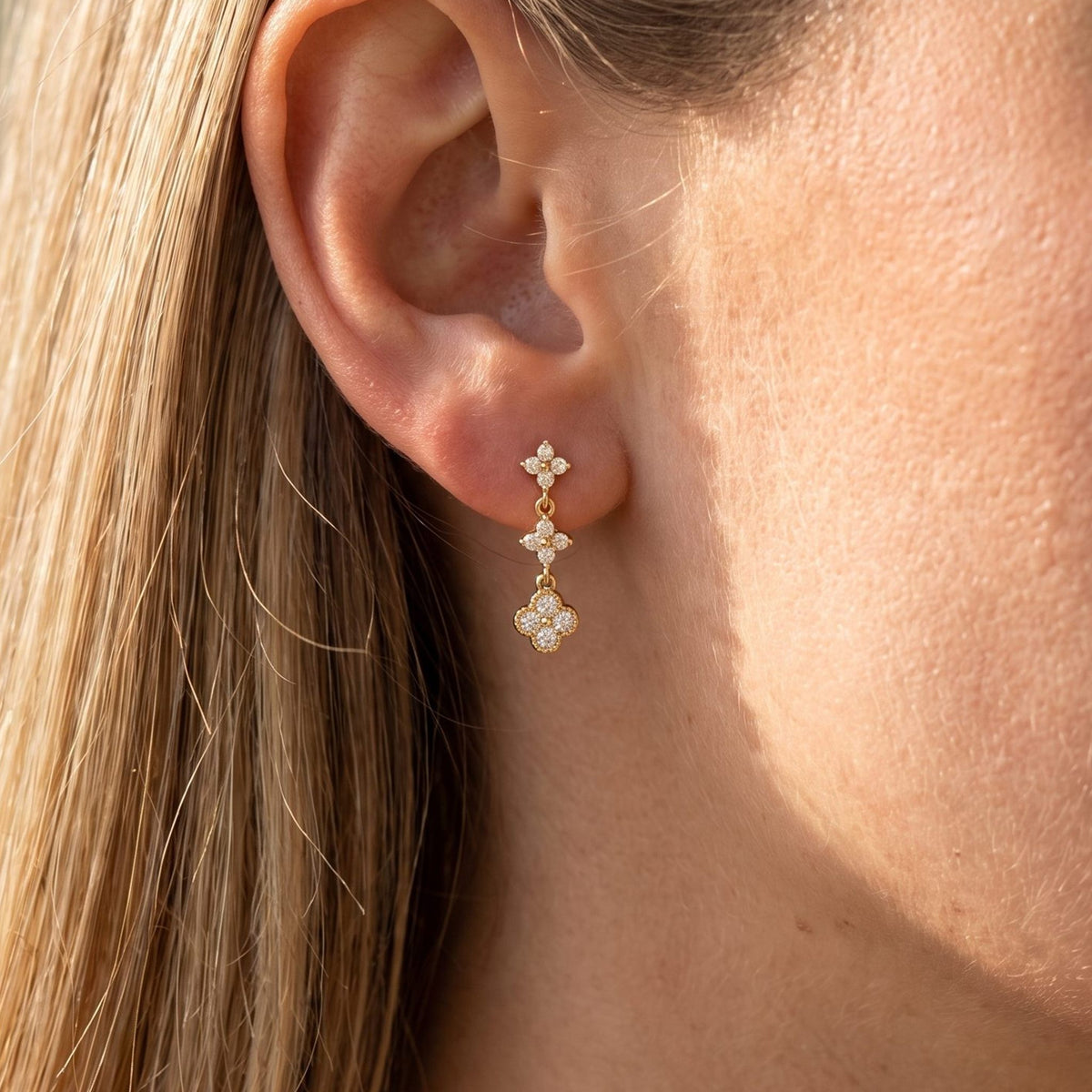 Woman wearing the Mia Sparkle Cluster Earrings hanging below the lobe with sparkling gold charms