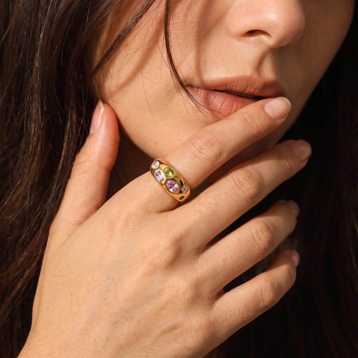 Woman wearing the Multicolour Dome Ring on her ring finger, with her hand touching her mouth
