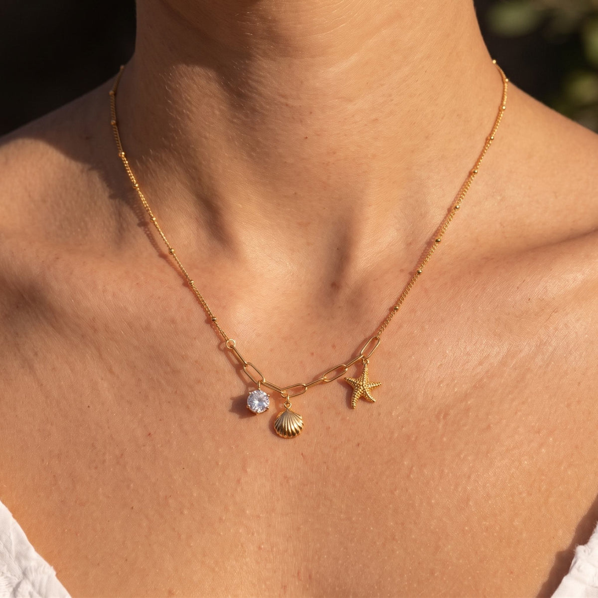 Close-up of the Ocean Charm Necklace worn on the neckline
