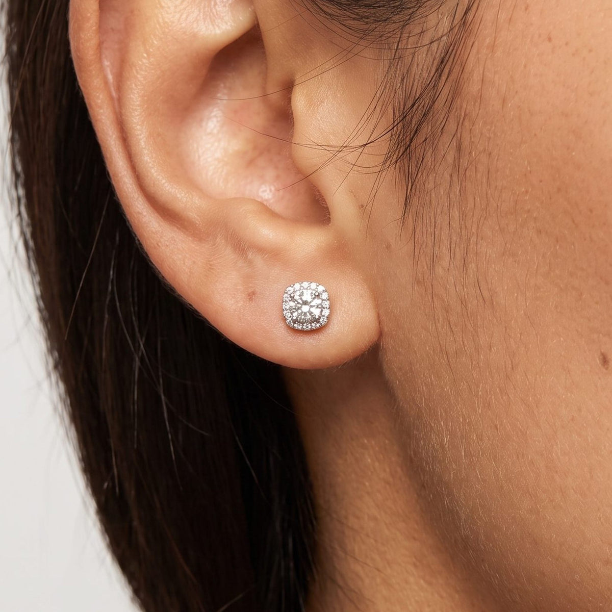Woman wearing the Olivia Escouade Halo Earrings on the lobe featuring a square silver-colored halo