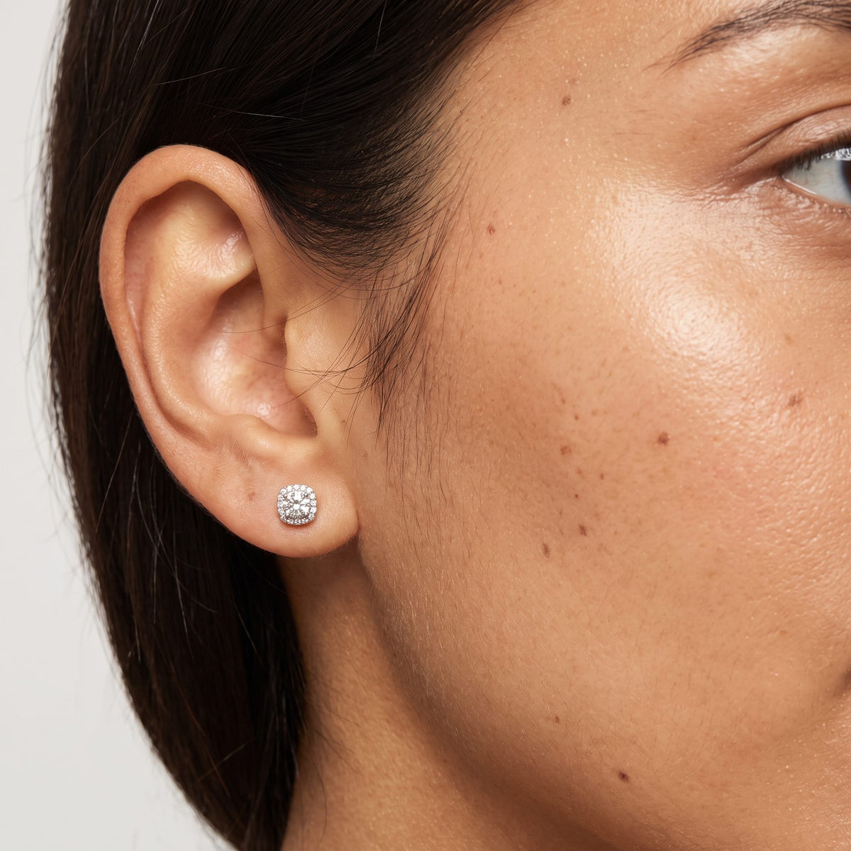 Woman wearing the Olivia Escouade Halo Earrings on the lobe featuring a square silver-colored halo