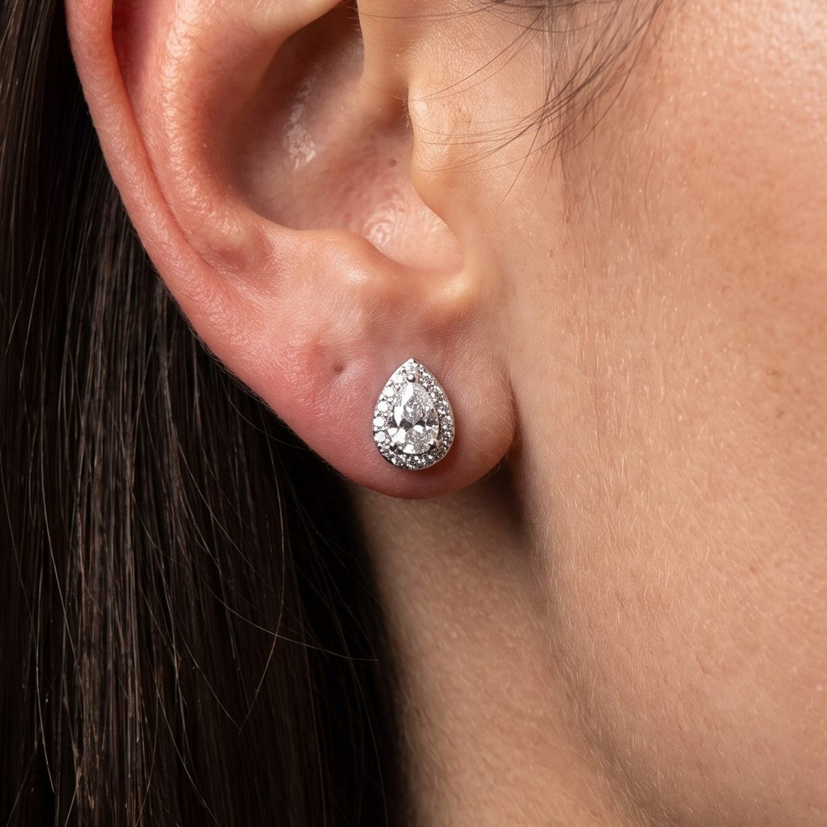 Woman wearing the Olivia Goutte Halo Earrings flat to the lobe, showcasing a sparkling teardrop shape