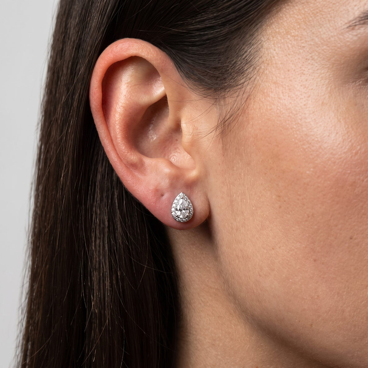 Woman wearing the Olivia Goutte Halo Earrings flat to the lobe, showcasing a sparkling teardrop shape