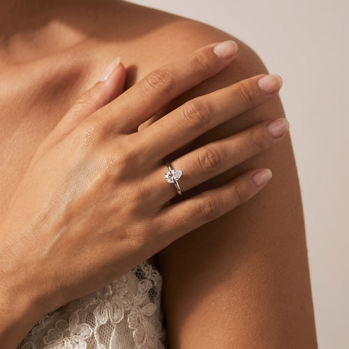 Wider view of a hand wearing the Pear Solitaire Ring