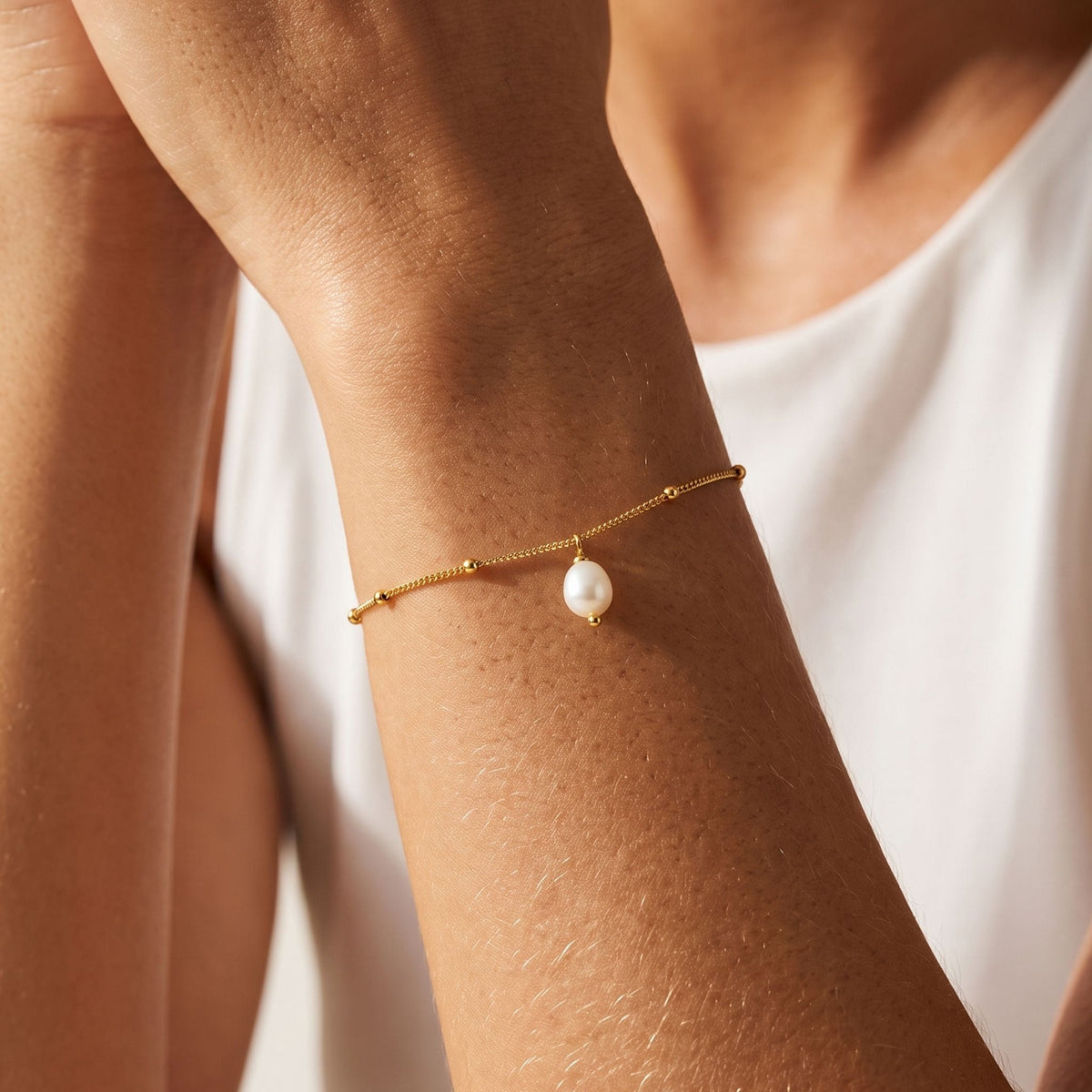 Pearl Drop Bracelet worn on the wrist, photographed in natural daylight.
