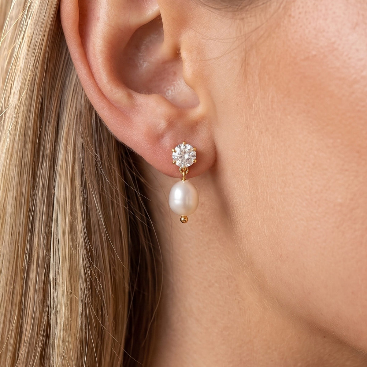 Close-up of the Pearl Drop Earrings on the ear featuring a sparkling crystal stud and pearl