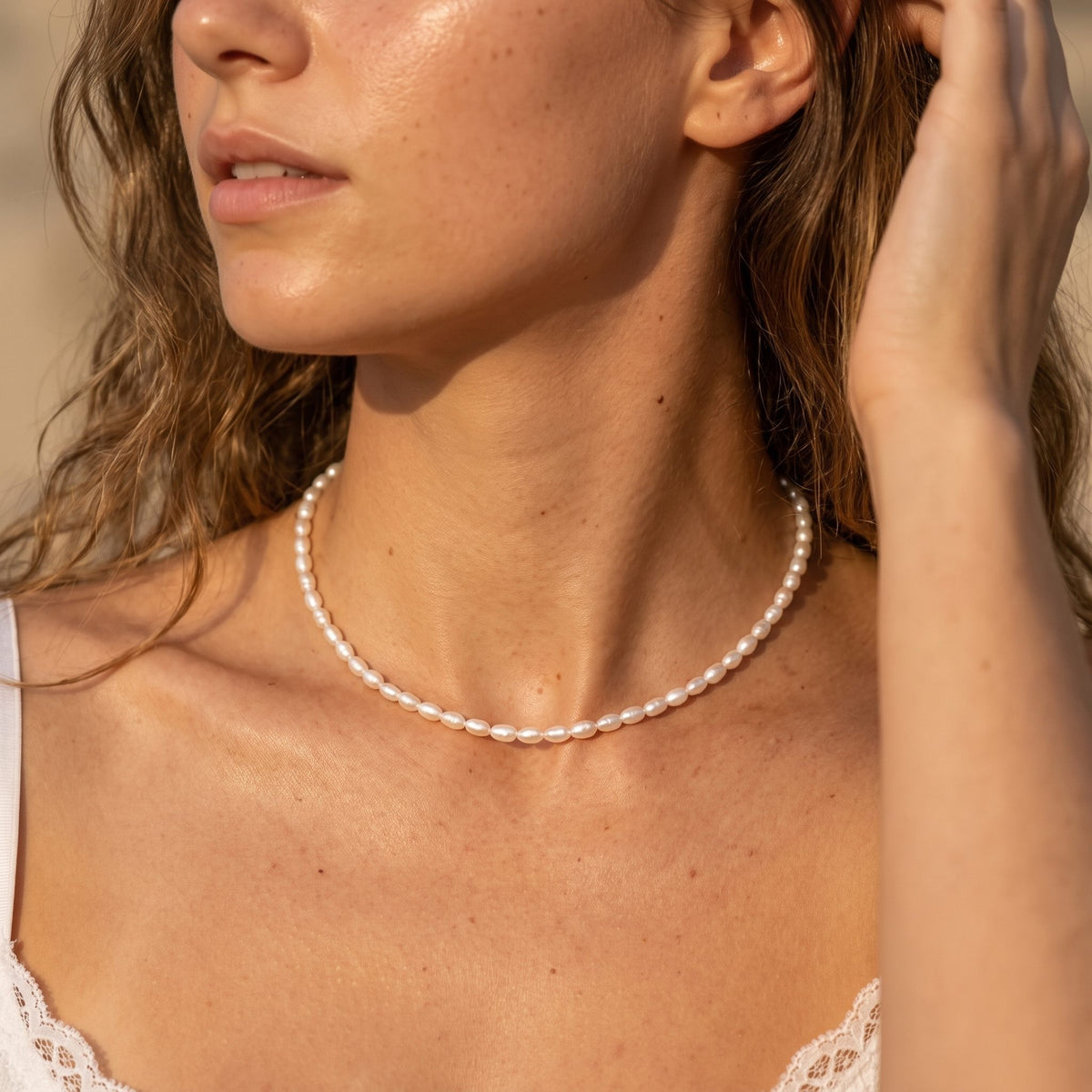 Woman wearing the Pearl Strand Necklace on the neckline