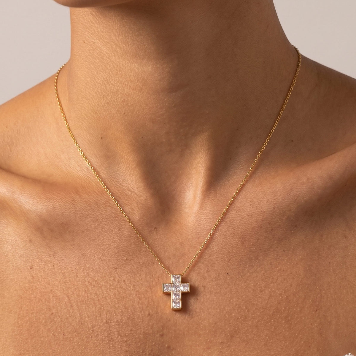Close-up of the Princess Cross Pendant at the collarbone showcasing sparkling square crystals