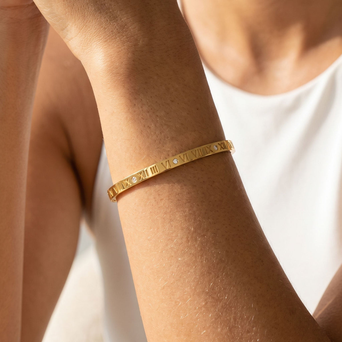 Roman Numeral Bangle worn on the wrist, photographed in natural daylight.