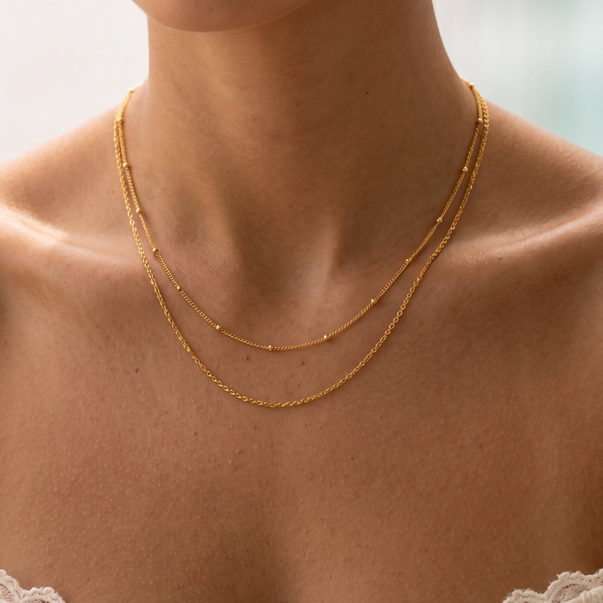 Close-up of the Satellite Layer Necklace worn on the neckline