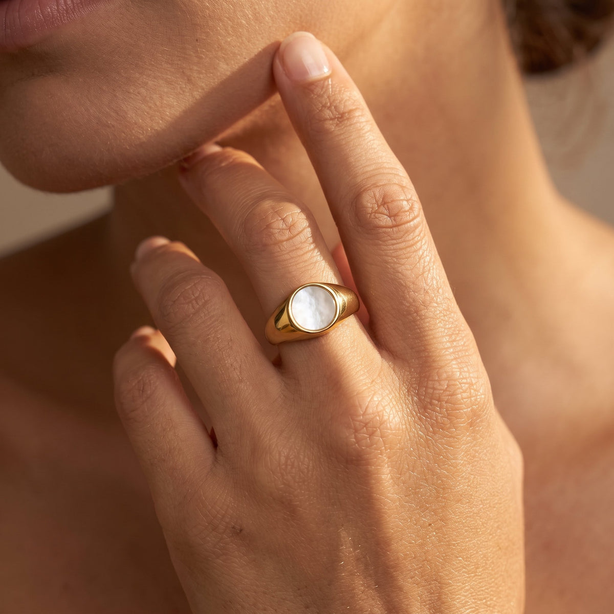 Wider view of a hand wearing the Shell Signet Ring